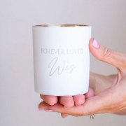 An elegant display of the Forever Loved Custom Engraved Candle, showcasing its powdery rose fragrance and timeless appeal for any heartfelt celebration.